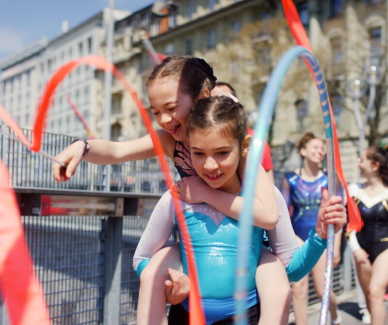 De jeunes gymnastes s'amusent avec leurs rubans et cerceaux à Lausanne au Flon.