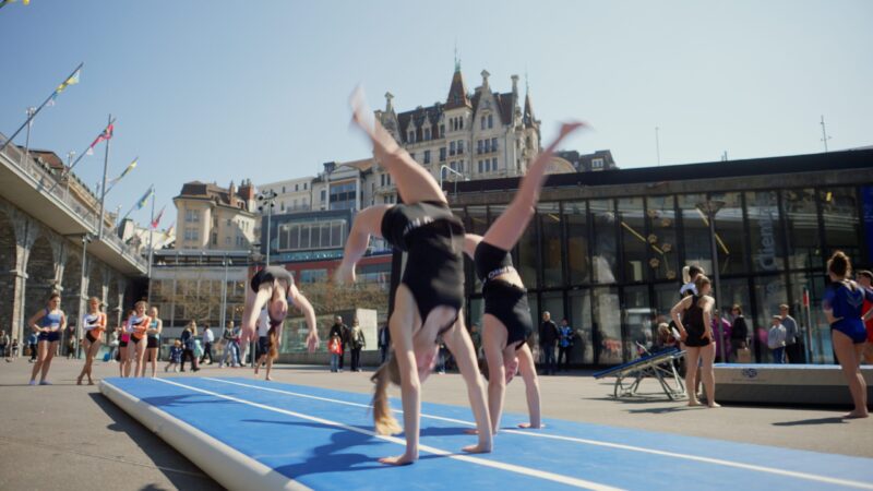 Des gymnastes font des figures sur la Place de l'Europe au Flon à Lausanne.