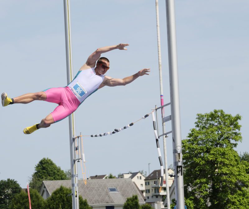 Un athlète pratique du saut à la perche lors d'une Fête fédérale de gymnastique.