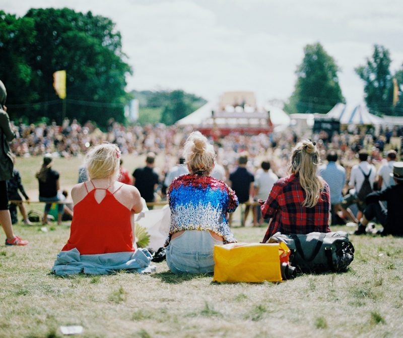 Trois personnes assises au sol durant un concert